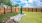 a fenced in yard with a stone bench and a tree