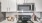 a stovetop in kitchen with white cabinets and granite countertopd