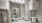 Bathroom with white cabinets, vanity sinks, and toilet